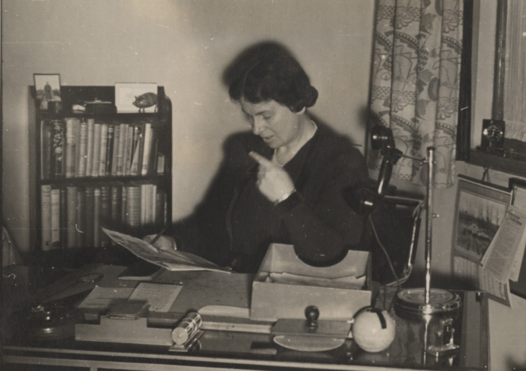 Black and white photograph of woman sitting at a desk